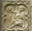 Panel 12:02 - Elderly, balding man, seated on ground, with buckler and pickaxe